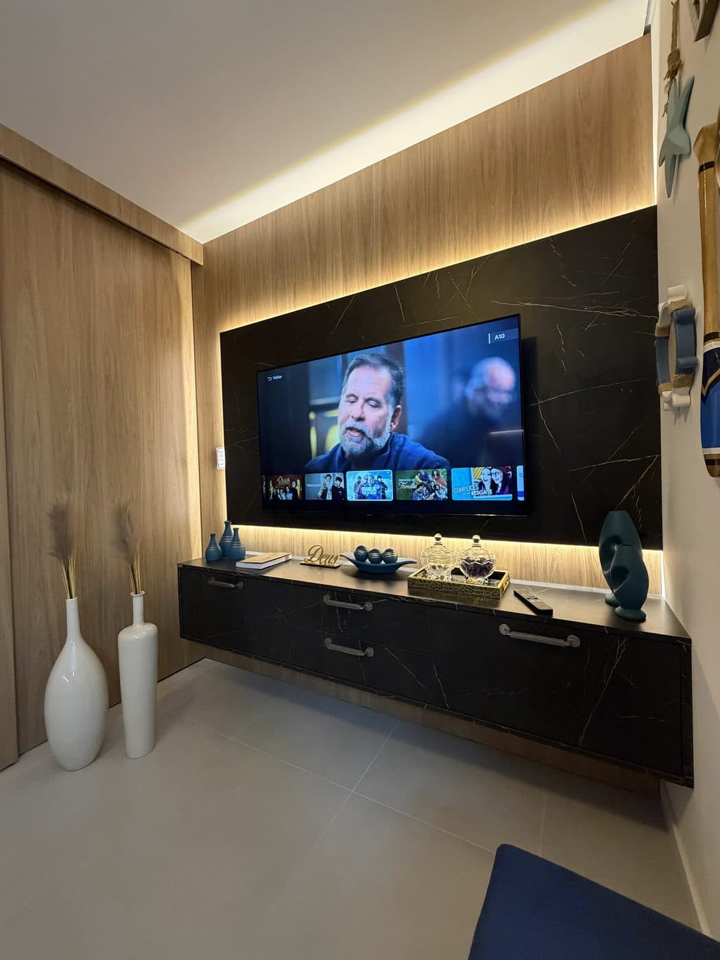 Sala planejada com painel ripado e acabamento em pedra